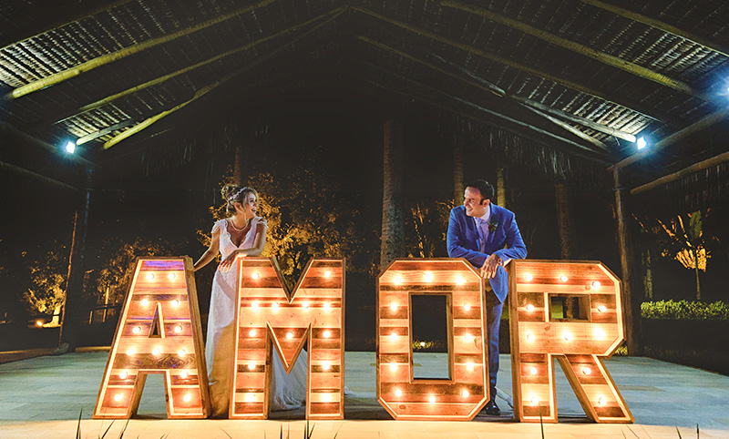 Casamento no campo de Thaís e Theo foto dos noivos no letreiro amor